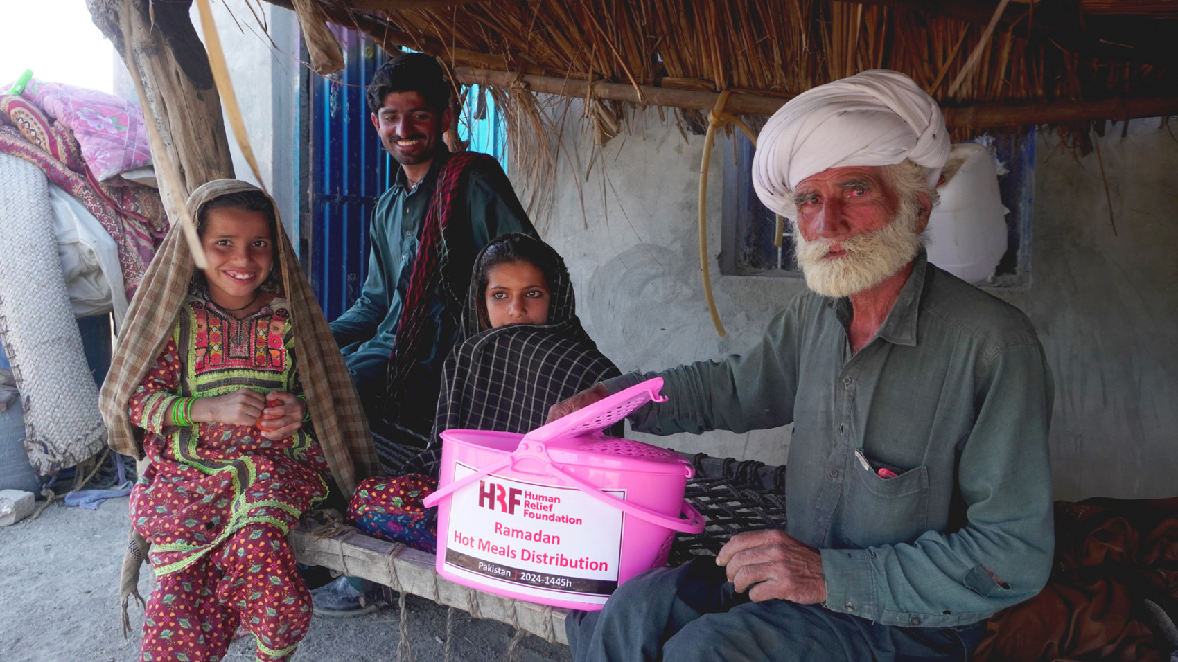 Family in Pakistan receiving an HRF hot meals pack during Ramadan 2024