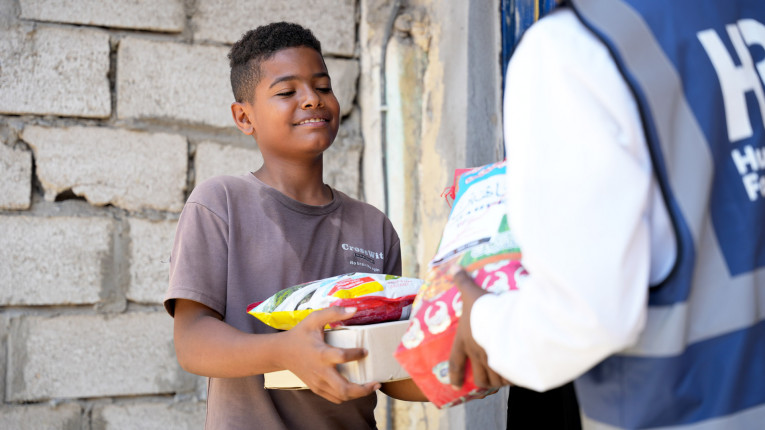 A Yemeni child received a food pack from an HRF aid worker.