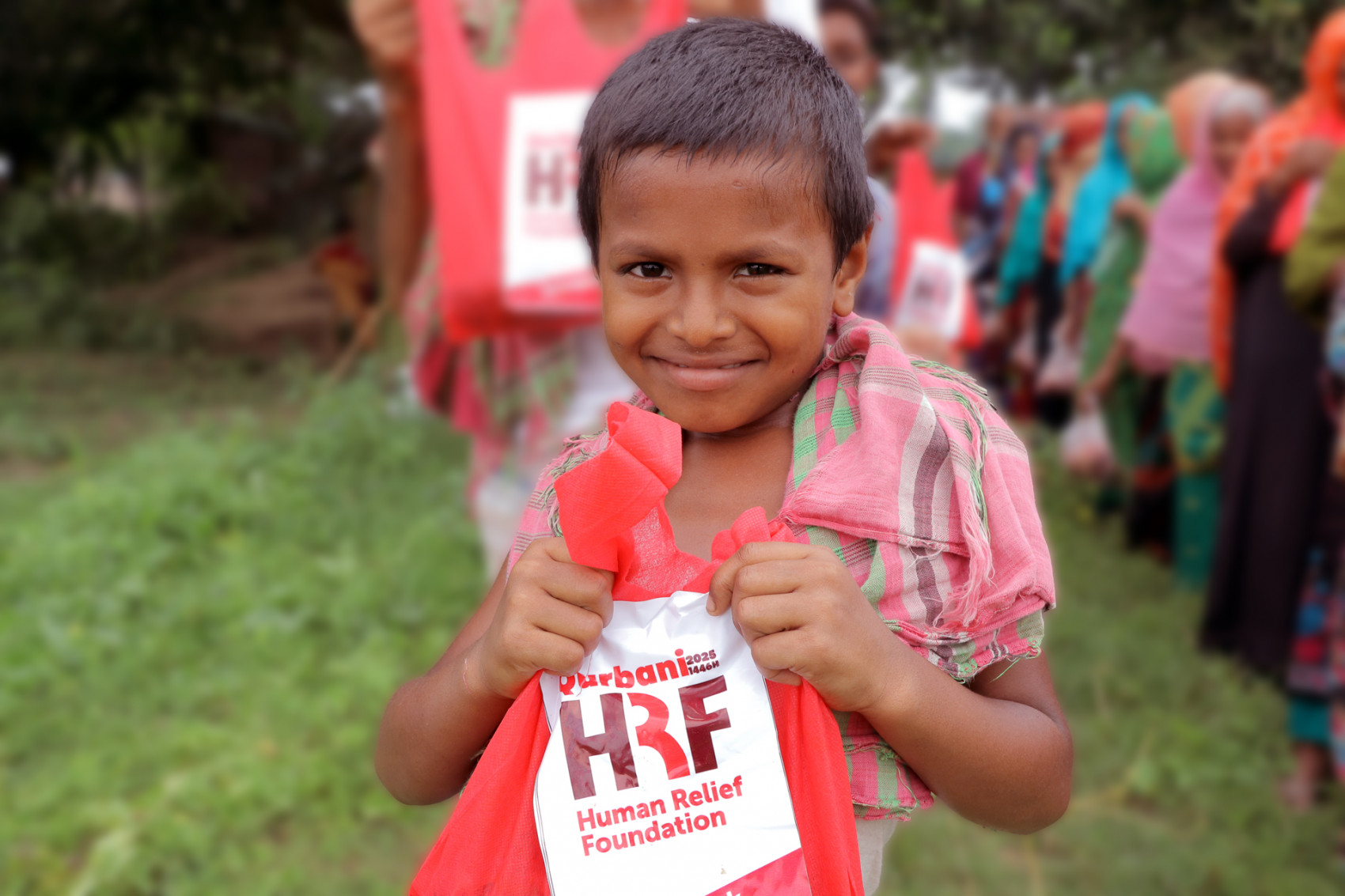 Young child receiving Qurbani meat for Eid al Adha